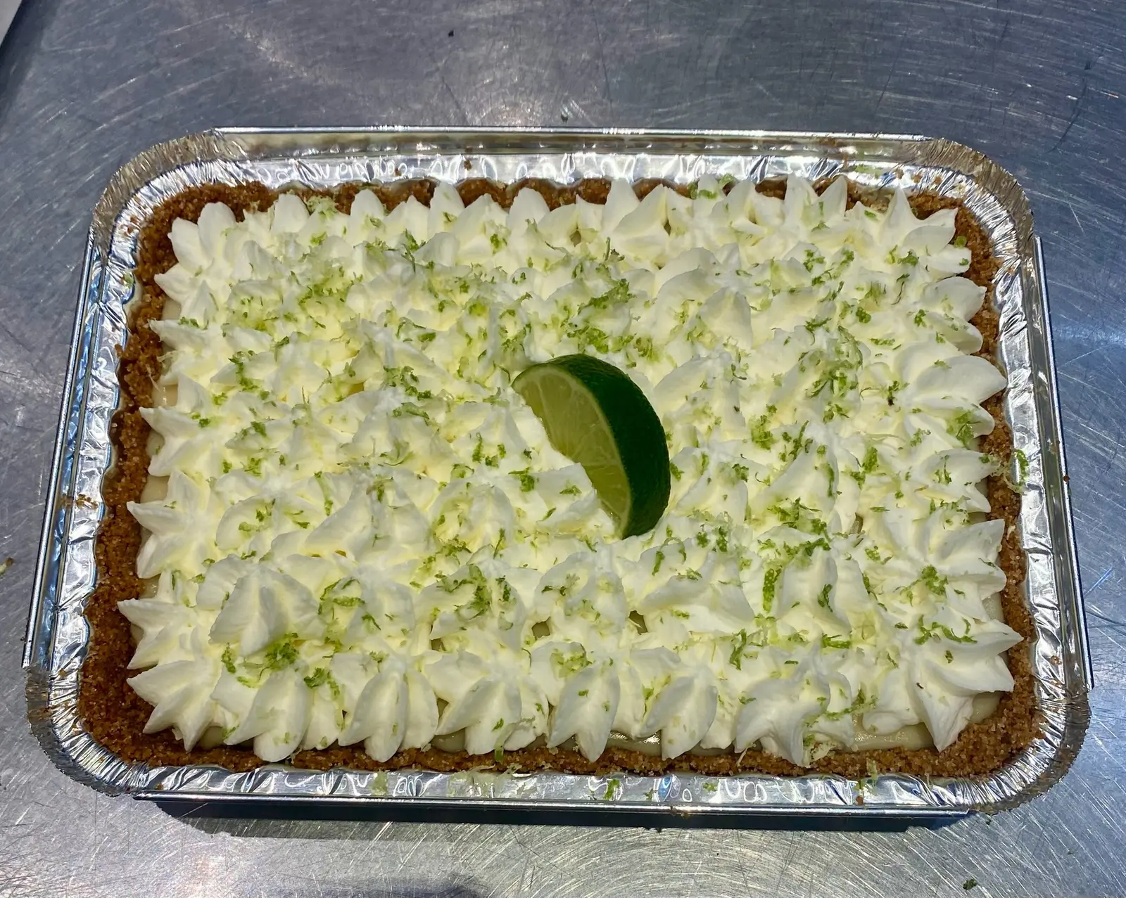 Key lime pie slab topped with piped cream